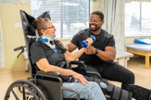 A nurse helping someone lift weights