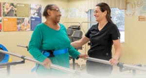 A therapist helping a woman walk
