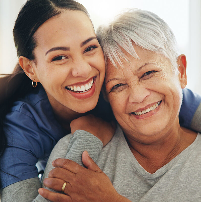 Happy woman, nurse and hug senior patient in elderly care, support or trust at old age home. Portrait of mature female person, doctor or medical caregiver hugging with smile for embrace at house